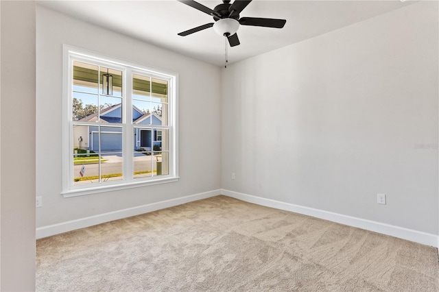 empty room with ceiling fan, carpet, and baseboards