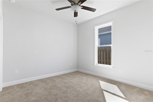 carpeted empty room featuring ceiling fan and baseboards