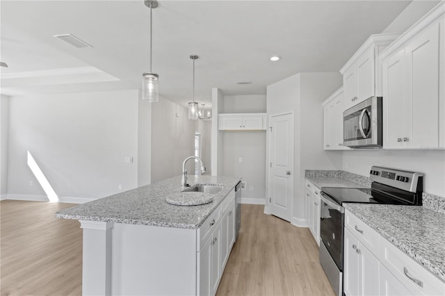 kitchen featuring light wood finished floors, stainless steel appliances, visible vents, white cabinets, and a sink