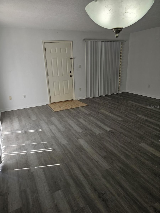 entrance foyer featuring a textured ceiling, baseboards, and wood finished floors