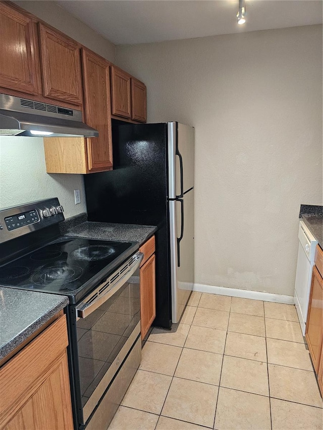 kitchen with light tile patterned floors, appliances with stainless steel finishes, dark countertops, and under cabinet range hood