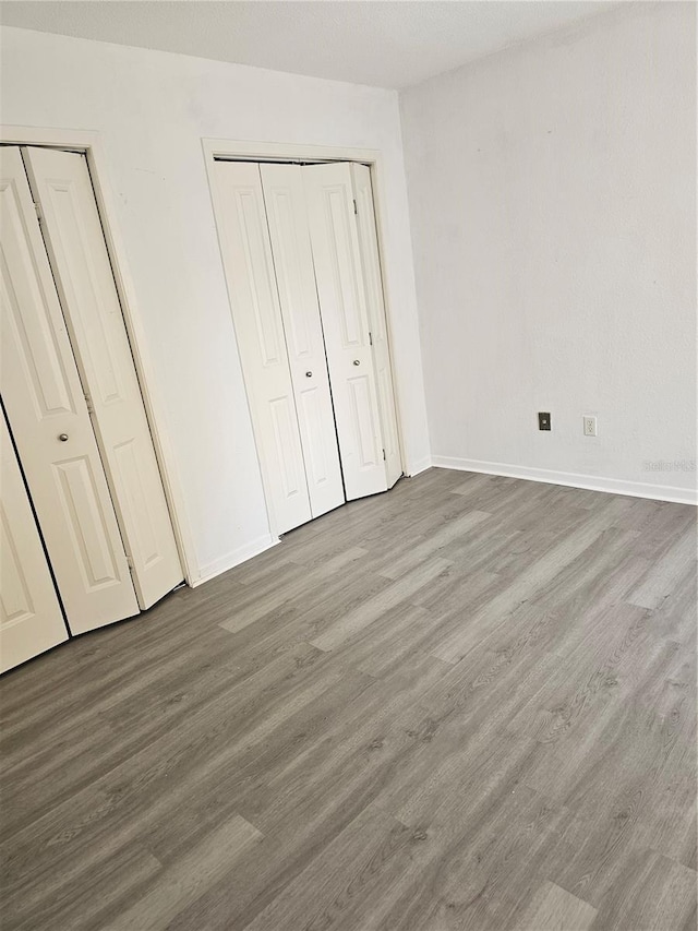 unfurnished bedroom featuring baseboards and wood finished floors