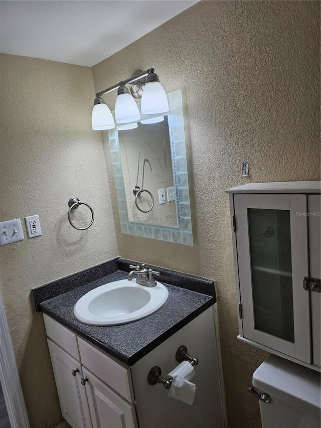 bathroom featuring a textured wall and vanity