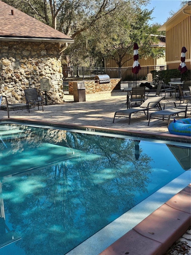 pool with fence and a patio