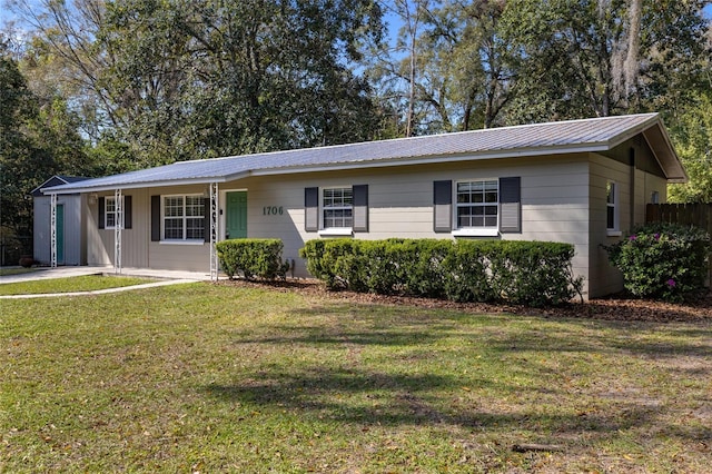 ranch-style house with metal roof and a front lawn