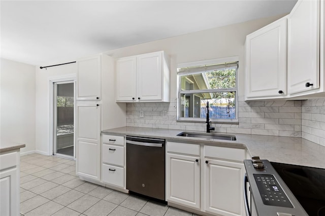 kitchen with light tile patterned floors, tasteful backsplash, stainless steel appliances, white cabinetry, and a sink