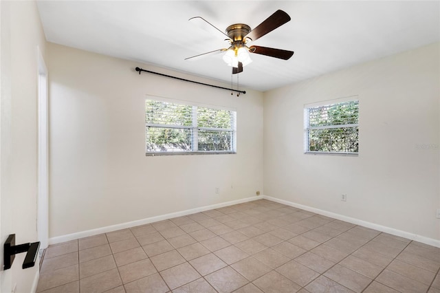 spare room featuring a ceiling fan, a wealth of natural light, and baseboards