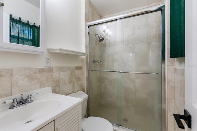 full bathroom with tile walls, a shower stall, toilet, and vanity