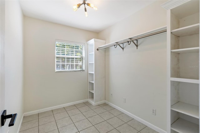 spacious closet featuring a chandelier and light tile patterned flooring