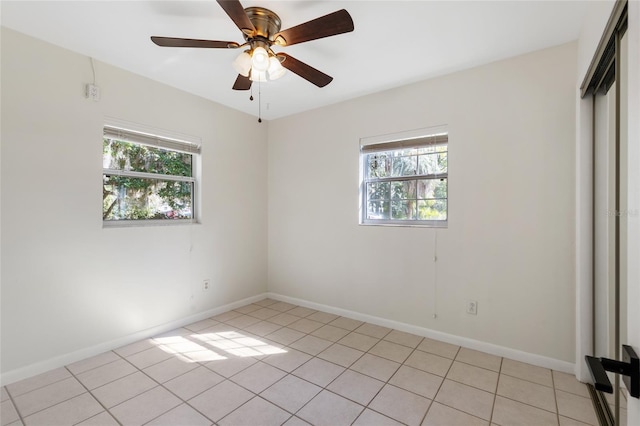 spare room featuring baseboards, a ceiling fan, and a healthy amount of sunlight