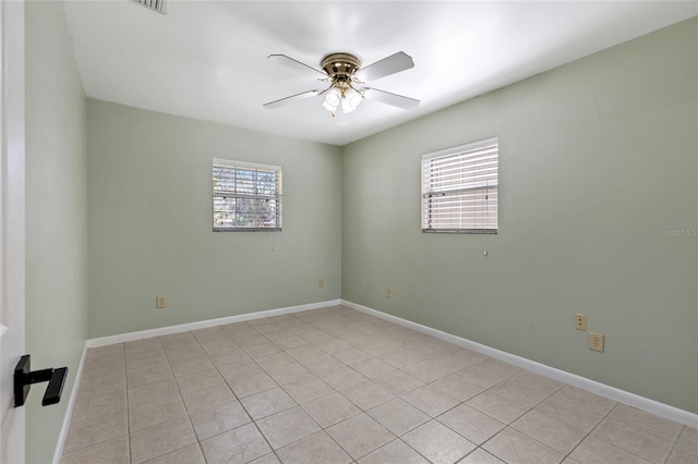 spare room featuring baseboards, a ceiling fan, and light tile patterned flooring