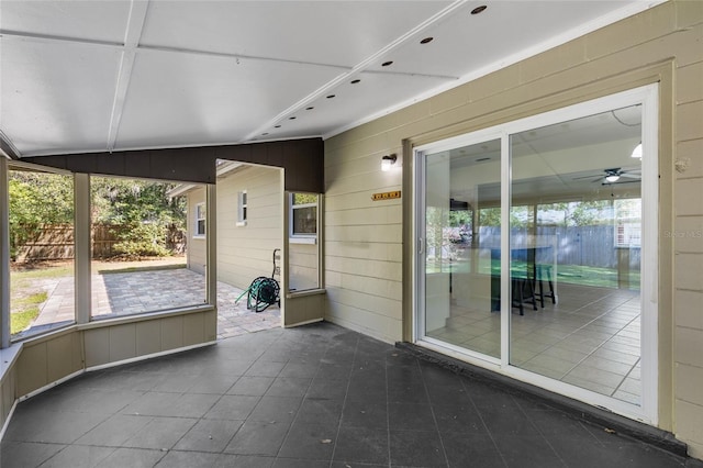 unfurnished sunroom with a ceiling fan