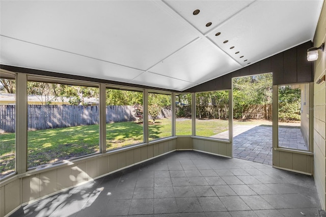 unfurnished sunroom featuring lofted ceiling and plenty of natural light