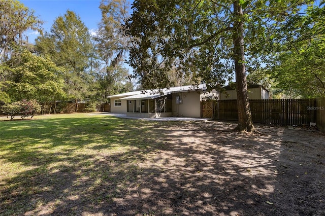 back of property featuring a fenced backyard and a lawn