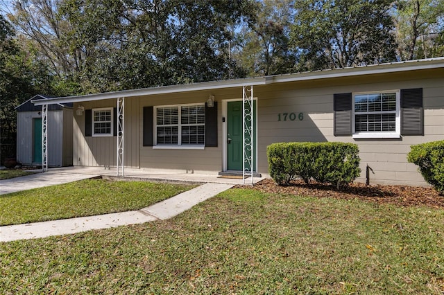 ranch-style home with covered porch and a front yard