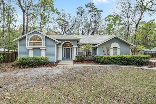 view of front of home featuring fence and roof with shingles