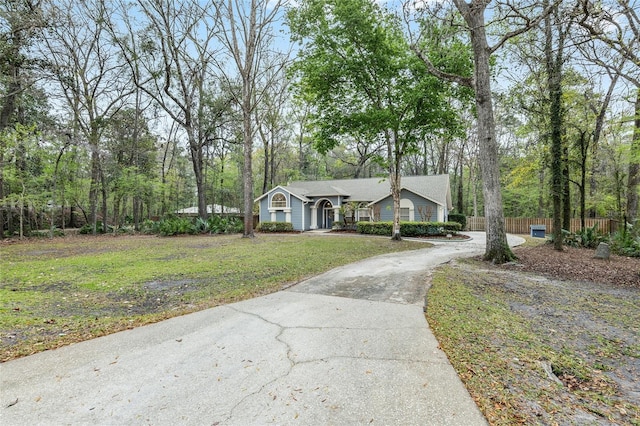 view of front of house with a front yard, fence, and driveway