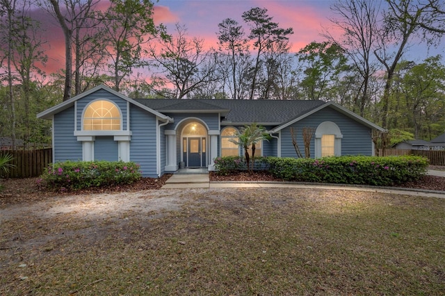 view of front of home with a lawn and fence