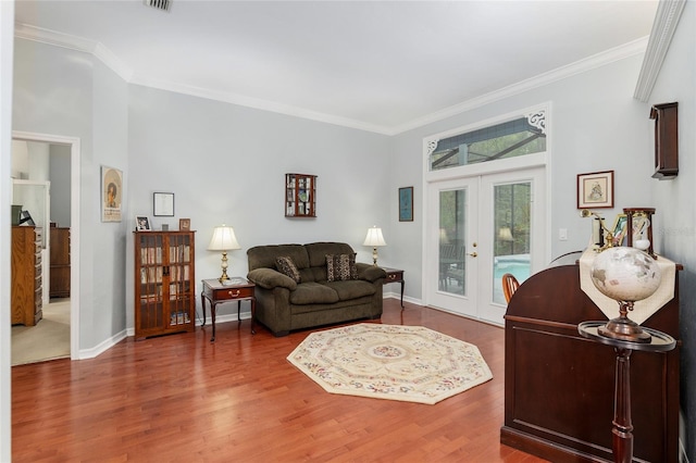 living room with ornamental molding, wood finished floors, and french doors