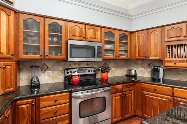 kitchen featuring stainless steel appliances, tasteful backsplash, brown cabinetry, and crown molding