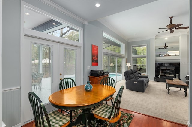 sunroom with a glass covered fireplace, a ceiling fan, and french doors