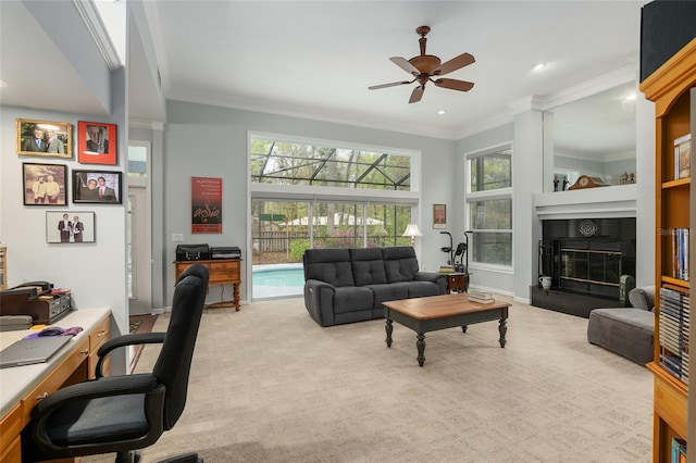 carpeted living room with ceiling fan, baseboards, crown molding, and a tile fireplace