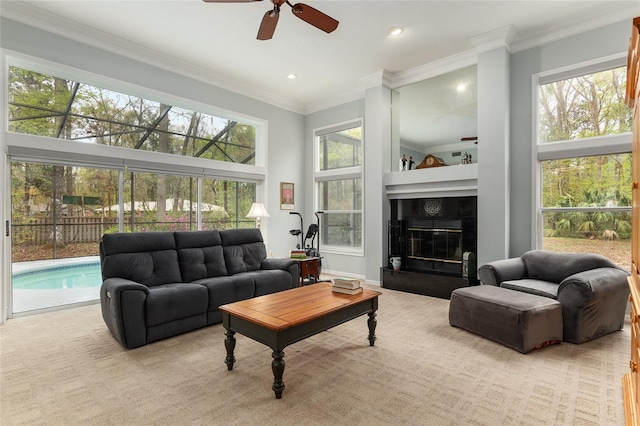 living area featuring a tile fireplace, recessed lighting, a ceiling fan, baseboards, and crown molding