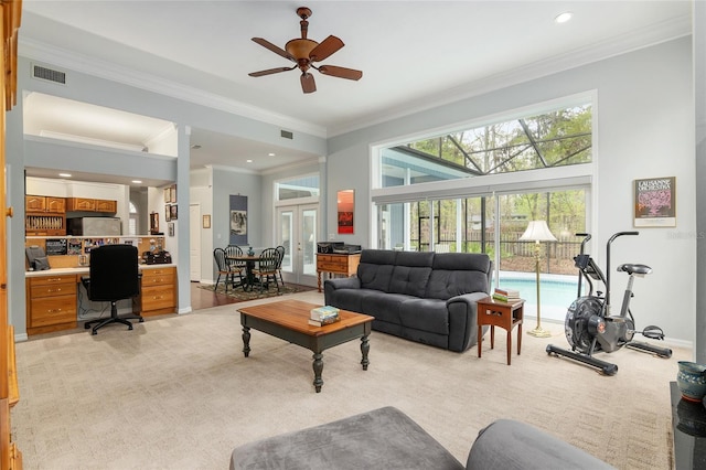 living area with light carpet, ceiling fan, visible vents, and crown molding