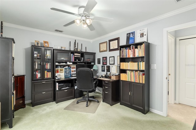 home office featuring light carpet, a ceiling fan, visible vents, baseboards, and ornamental molding