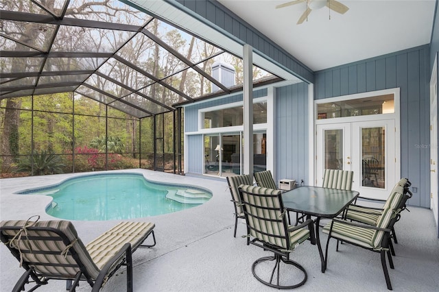 outdoor pool featuring glass enclosure, french doors, a patio area, and a ceiling fan