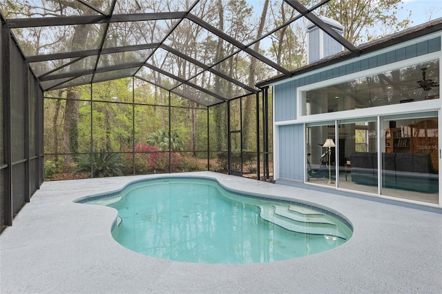 pool featuring glass enclosure and a patio area