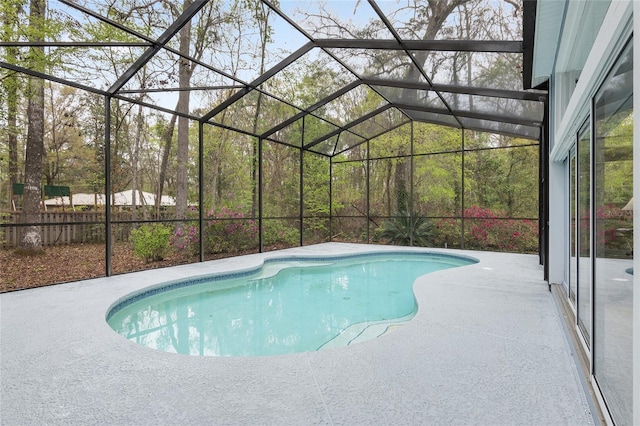 pool featuring glass enclosure and a patio area