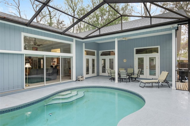 outdoor pool with glass enclosure, a ceiling fan, a patio, and french doors