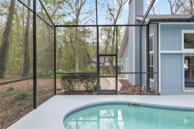 pool featuring glass enclosure and a patio