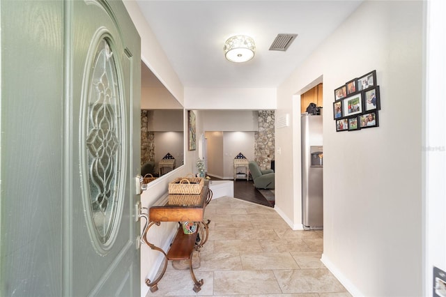 corridor featuring baseboards and visible vents