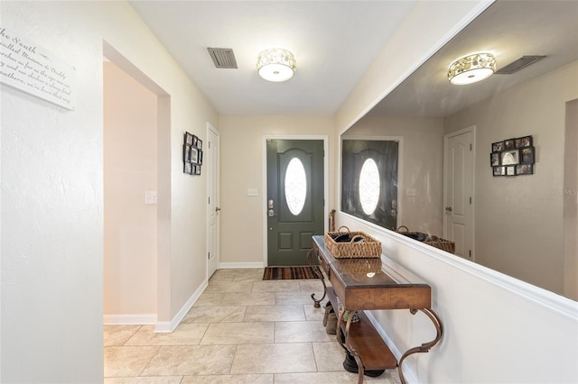 foyer with baseboards and visible vents