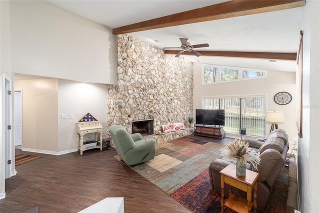 living area featuring beam ceiling, a ceiling fan, a stone fireplace, wood finished floors, and baseboards