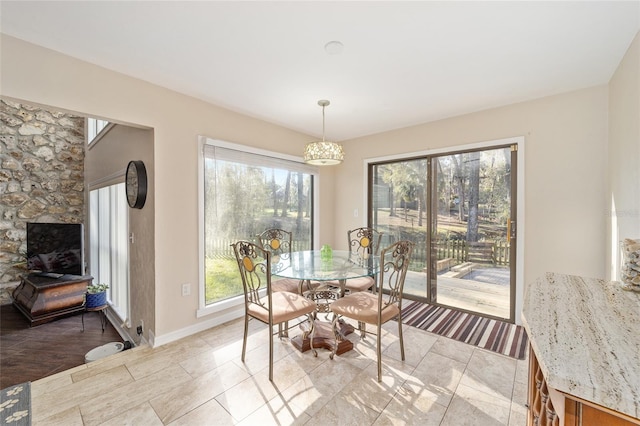 dining room with a healthy amount of sunlight, light tile patterned floors, and baseboards