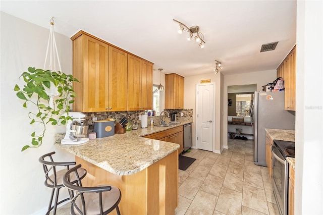 kitchen featuring visible vents, backsplash, appliances with stainless steel finishes, light stone countertops, and a peninsula