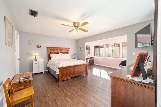 bedroom with dark wood-type flooring, visible vents, baseboards, and a ceiling fan