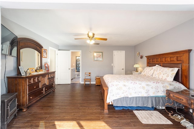 bedroom featuring dark wood-style floors, ensuite bathroom, a ceiling fan, and baseboards