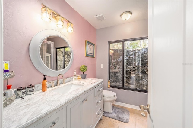 bathroom featuring baseboards, visible vents, toilet, tile patterned flooring, and vanity