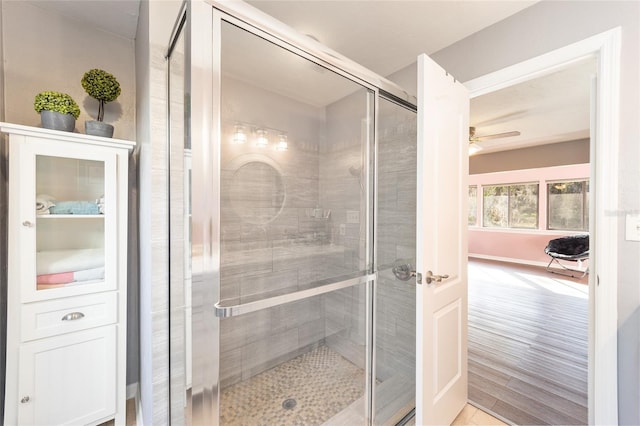 bathroom featuring a ceiling fan and a stall shower