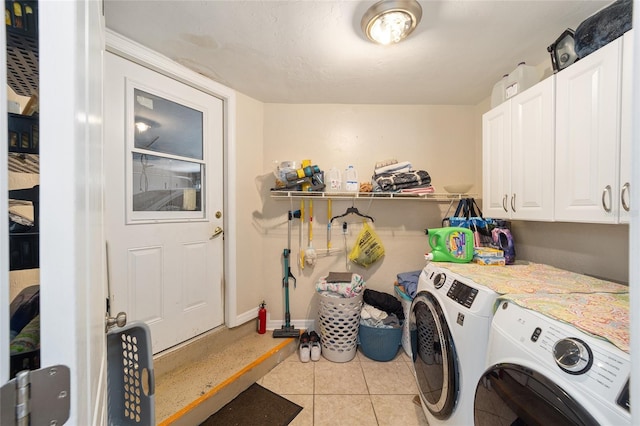 laundry room featuring cabinet space, washer and clothes dryer, and tile patterned floors