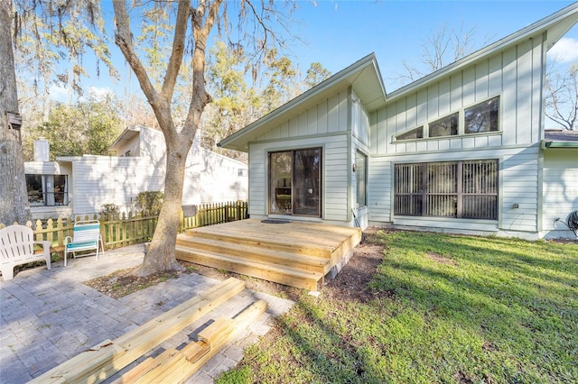 wooden terrace featuring fence, a lawn, and a patio