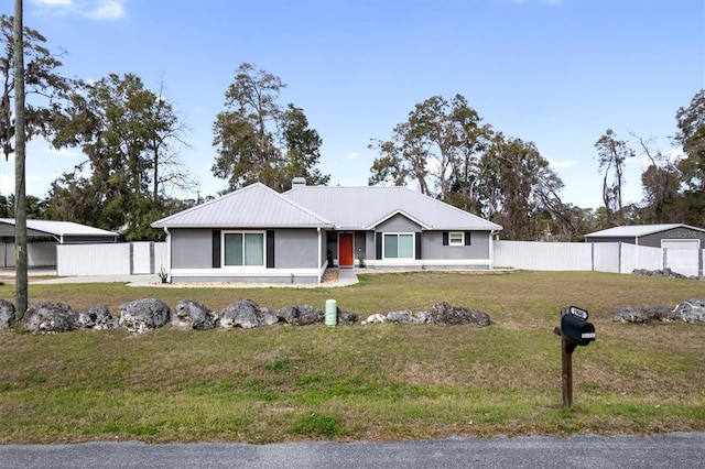 view of front of home with a front lawn, fence, metal roof, and stucco siding