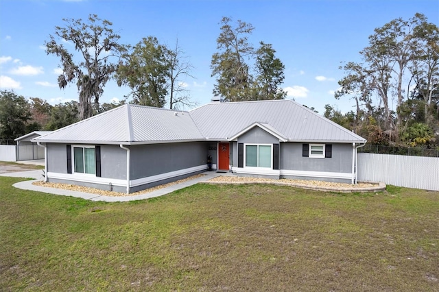 ranch-style house with metal roof, a front lawn, and fence