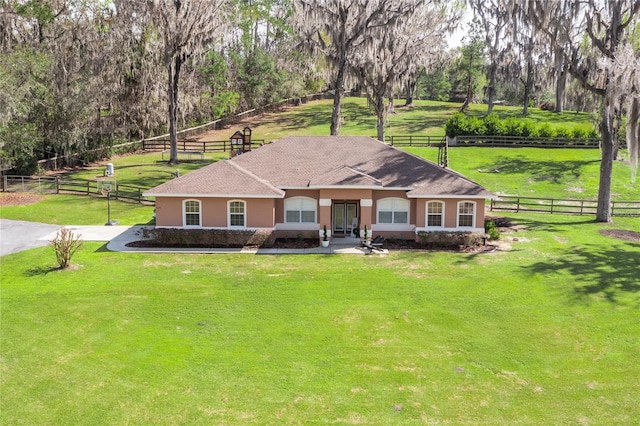 view of front of home with fence, a front lawn, and stucco siding