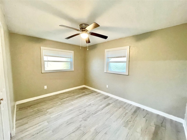 unfurnished room featuring ceiling fan, plenty of natural light, wood finished floors, and baseboards