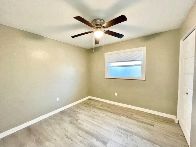 unfurnished bedroom featuring ceiling fan, a closet, wood finished floors, and baseboards